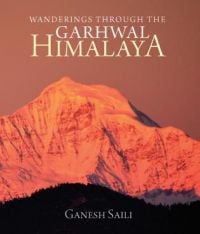 Book cover of Wanderings Through the Garhwal Himalaya, with a sunset lighting up a snow-covered mountain. Published by Niyogi Books.