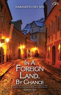 Book cover of In a Foreign Land, By Chance, with a lit alleyway of cobbled stones. Published by Niyogi Books.