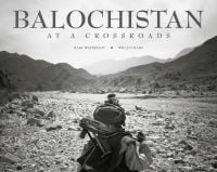 Book cover of Balochistan: At a Crossroads, with a man walking with a gun over shoulder. Published by Niyigi Books.