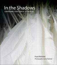 Book cover of In the Shadows: Unknown Craftsmen of Bengal, with white feathers. Published by Niyogi Books.
