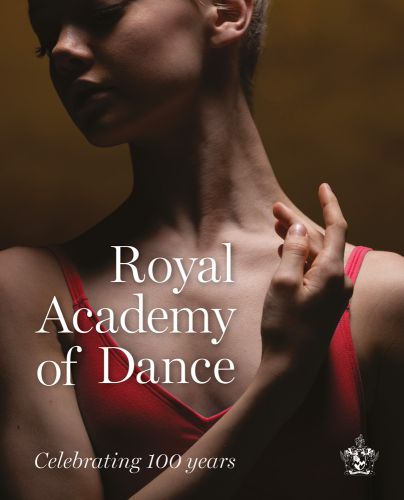 Head and shoulders pose of ballerina in red top, right arm across chest, Royal Academy of Dance in white font to lower left.