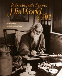Book cover of Rabindranath Tagore: His World of Art, with the poet sitting at a table painting. Published by Niyogi Books.