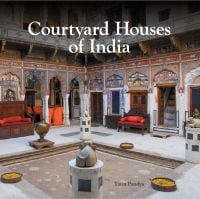 Book cover of Courtyard Houses of India, with an interior courtyard with stone sculptures, and carved wood furniture. Published by Mapin Publishing.