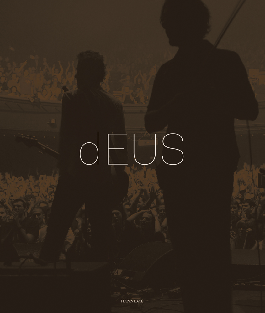 Rear view of two members of rock band on stage, facing large crowd, on cover of 'dEUS', by Hannibal Books.