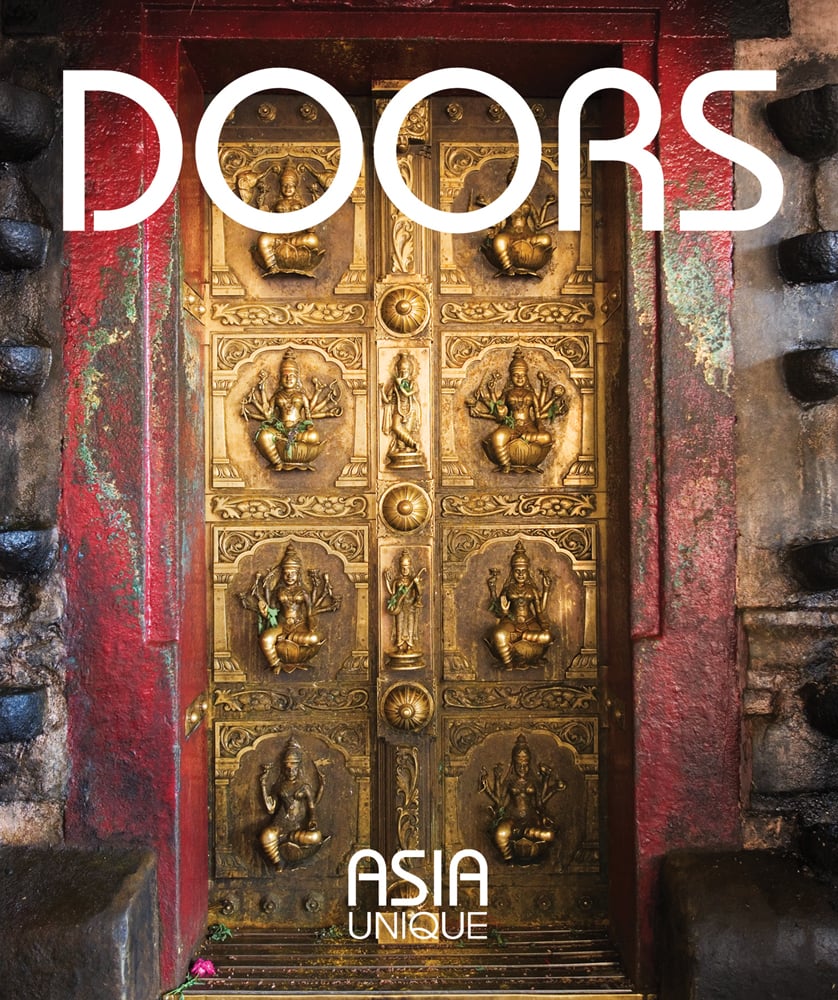 Highly decorative gold door to large building, DOORS in white font above, ASIA UNIQUE in white font to bottom edge.