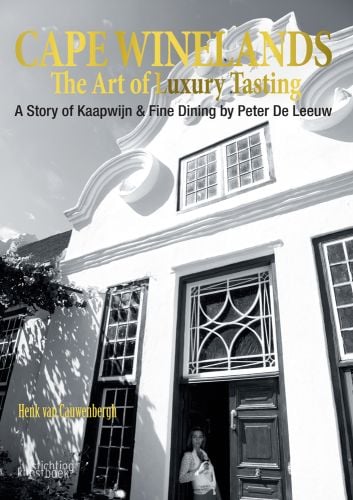 White Cape Dutch architecture building, female standing in doorway with glass of wine, CAPE WINELANDS The Art of Luxury Tasting in gold font above.