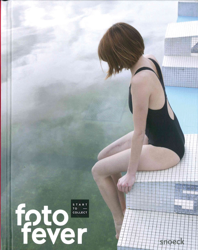 Book cover of Fotofever 2019: International Contemporary Photography Art Fair, featuring a female in black bathing suit sitting on edge of sheer drop. Published by Exhibitions International.