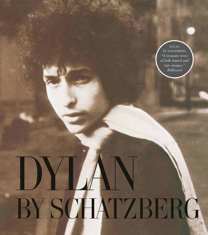 Bob Dylan in a white scarf looking at camera, on cover of 'Dylan By Schatzberg', by ACC Art Books.