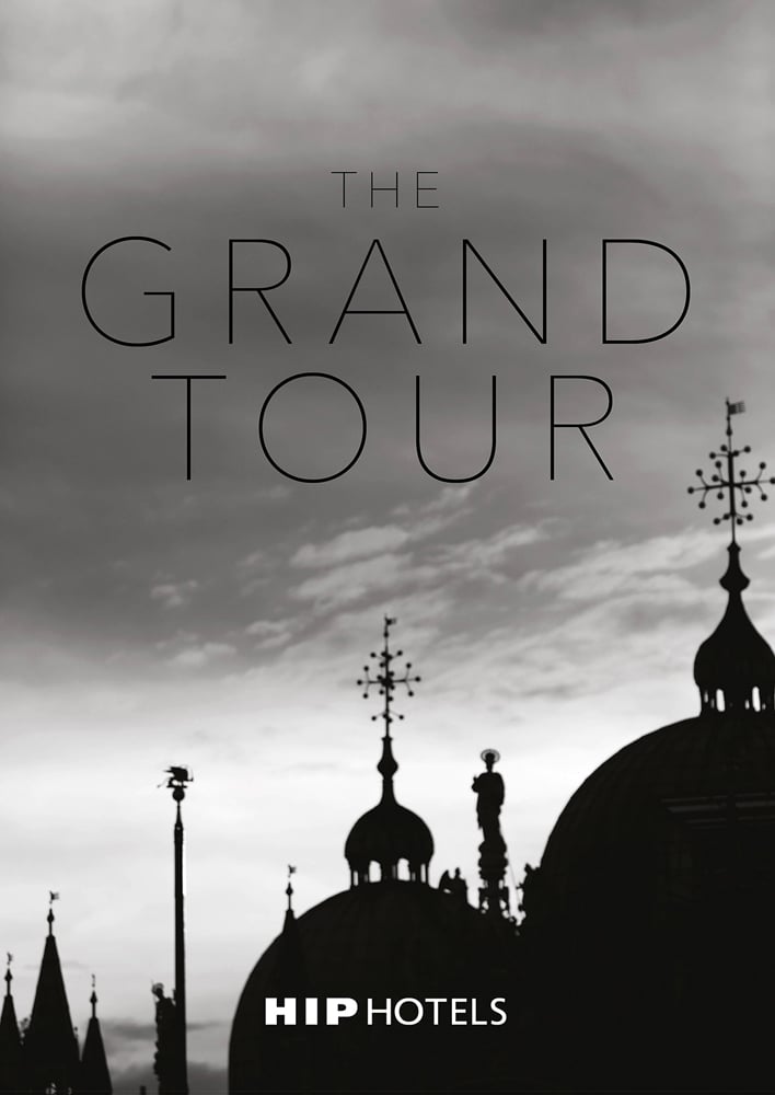 Atmospheric silhouette of domed hotel roof tops with decorative spires, THE GRAND TOUR in black font above, HIP HOTELS in white font below.