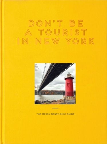 Little red lighthouse under great grey bridge on Hudson River, on yellow cover of 'Don't Be a Tourist in New York', by 13 Things Ltd.