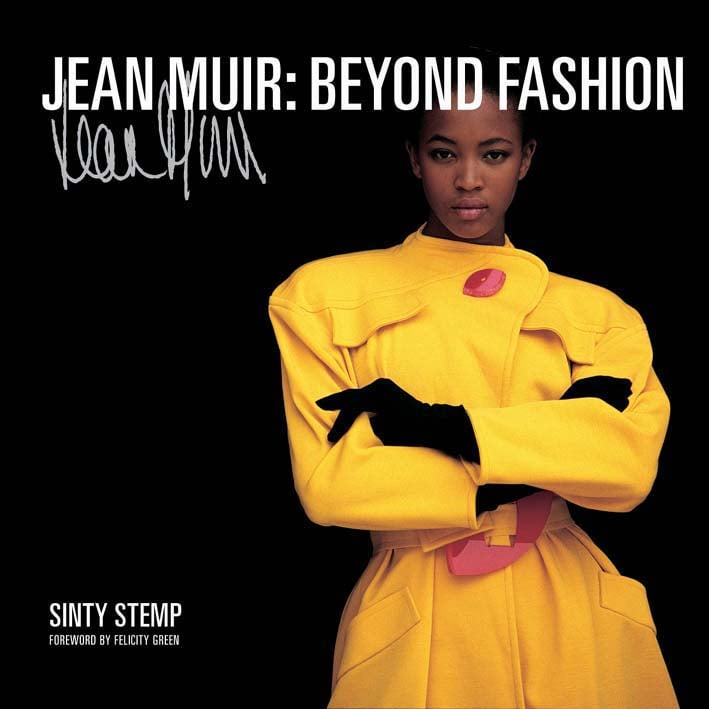 Fashion model in bright yellow belted coat, on black cover of 'Jean Muir, Beyond Fashion', by ACC Art Books.