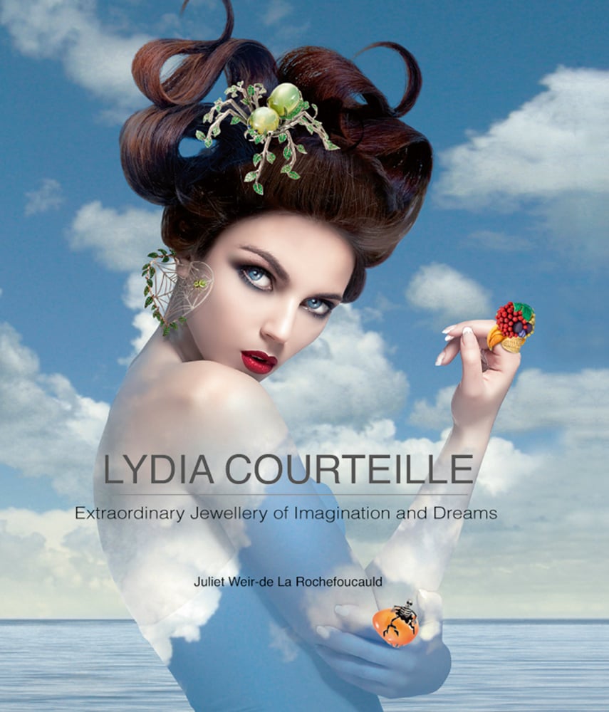 Model wearing green spider in hair, cloudy blue sky behind, on cover of 'Lydia Courteille Extraordinary Jewellery of Imagination and Dreams, by ACC Art Books.