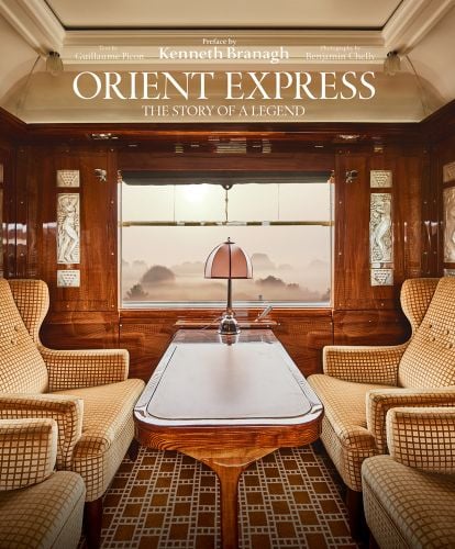 Colour interior photo of four luxury seats and table near window inside Orient Express train with Orient Express The Story of a Legend in white font above