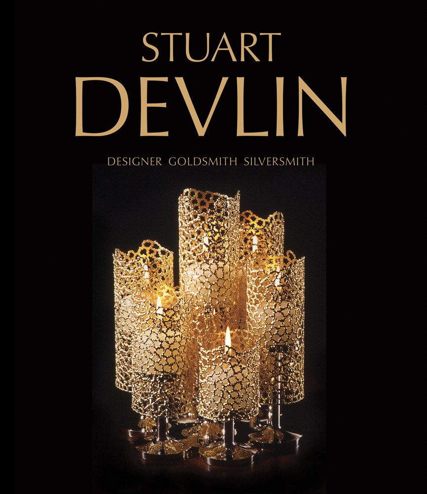 Set of 6 gold latticed candle holders with lit candles inside, on black cover of 'Stuart Devlin, Designer Goldsmith Silversmith', by ACC Art Books.