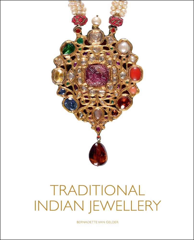 Pendant in the style of single flower on stem with a carved cabochon ruby in centre, on white cover of 'Traditional Indian Jewellery', by ACC Art Books.