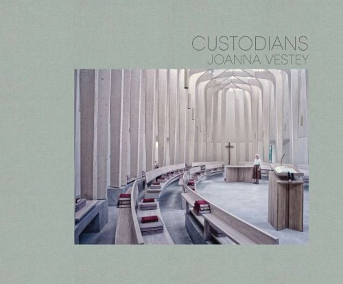 Interior of Bishop Edward King Chapel with long wooden pews, on landscape cover of 'Custodians', by Ashmolean Museum.