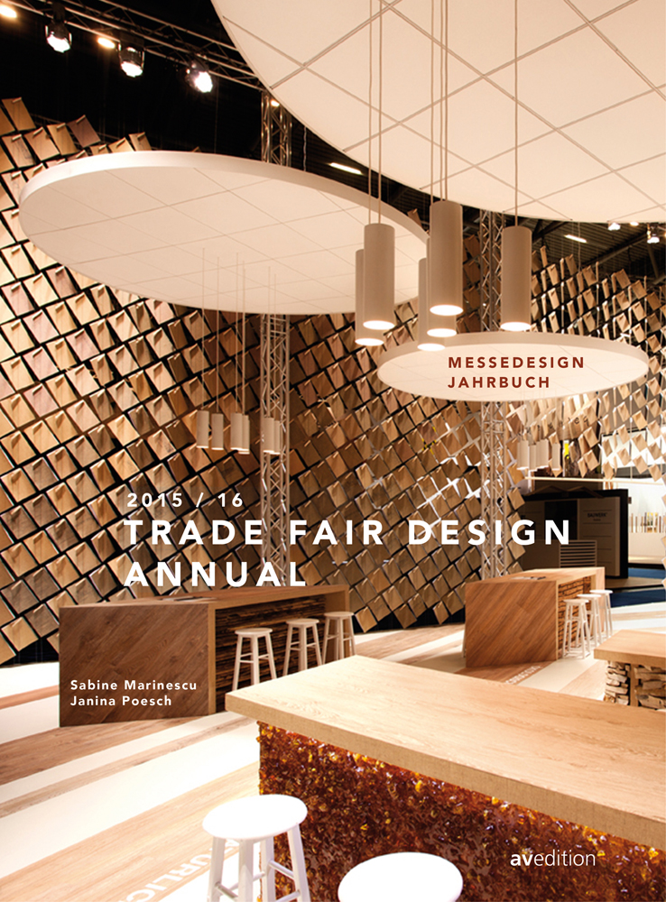 Interior exhibition with wood islands and stools, low hanging lights, on cover of 'Trade Fair Design Annual 2015/2016', by Avedition Gmbh.
