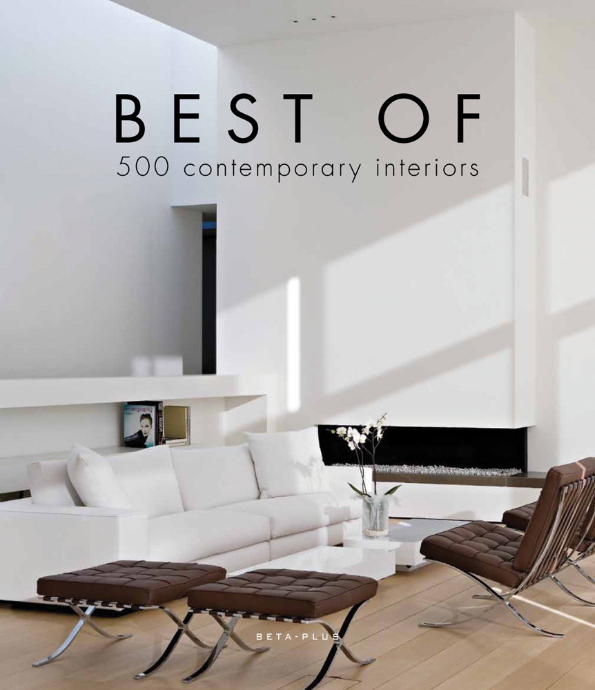 Figure walking away through interior corridor with looming light grey walls and Andrew Martin Interior Design Review in black font above