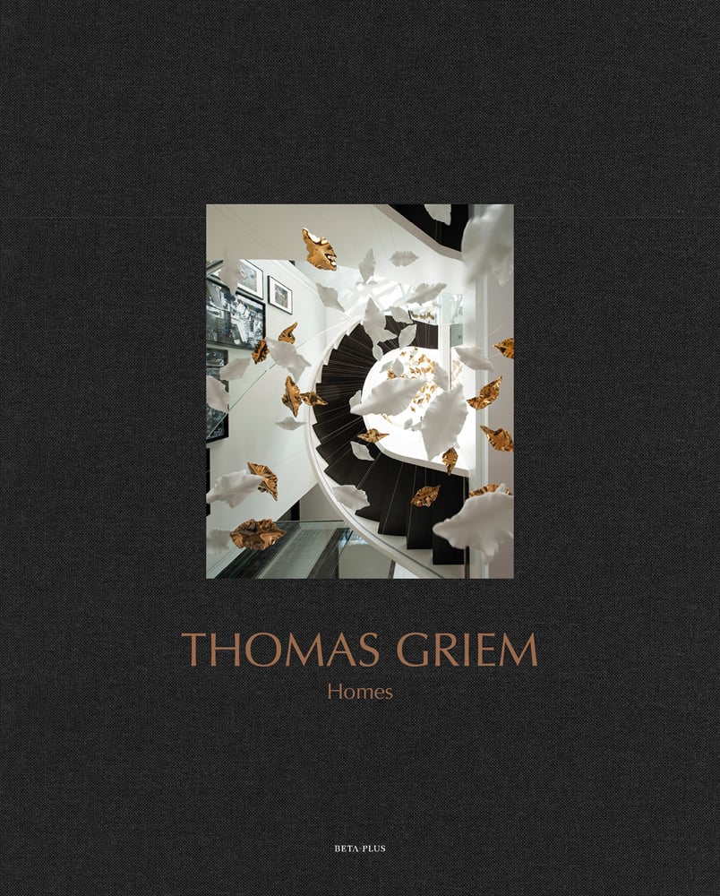 Surreal interior space with rotated staircase, gold and white objects floating in air, on black cover, of 'Thomas Griem, Homes', by Beta-Plus.