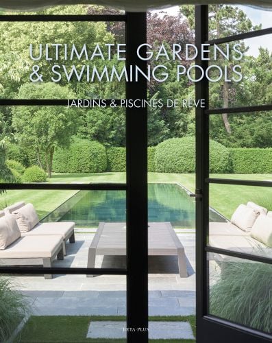 View of swimming pool in landscaped garden from interior glass doors, table and chairs on patio, ULTIMATE GARDENS & SWIMMING POOLS in pale blue font above.