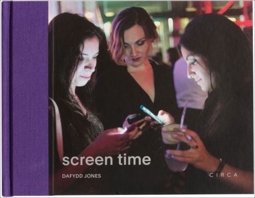 A group of 3 women looking at their mobile phones, screen time in grey font to bottom left, purple spine on left.