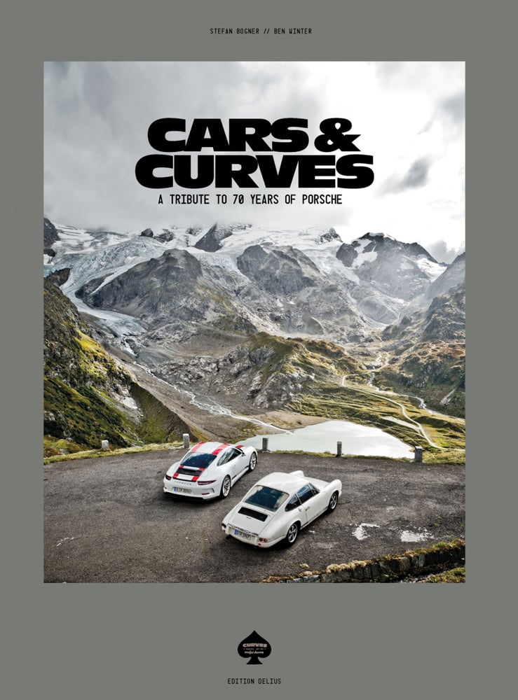 2 white Porsche's parked mountain roadside, on grey cover, Cars & Curves in black font above