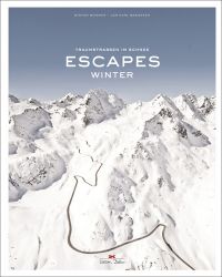 Aerial view of snow covered mountains with winding road, on cover of 'Escapes: Winter', by Delius Klasing.