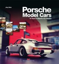 Rear-view of white Porsche 911 miniature model, on grey table, on cover of 'Porsche Model Cars, 70 Years of Sports Car History', by Delius Klasing.