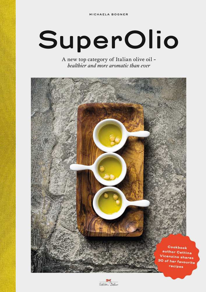 Aerial shot of three white ramekins with handles, filled with olive oil, on wood tray, on cover of 'Super Olio, A New Top Category of Italian Olive Oil - Healthier and More Aromatic Than Ever', by Delius Klasing.