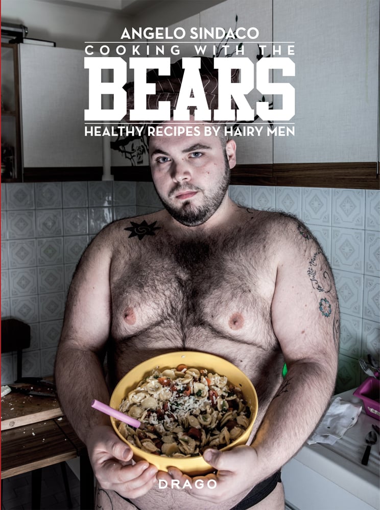Topless hairy male with tattoos, holding bowl of pasta in kitchen, 'COOKING WITH THE BEARS HEALTHY RECIPES BY HAIRY MEN', in white font above.