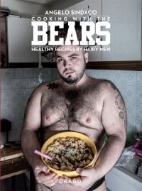 Topless hairy male with tattoos, holding bowl of pasta in kitchen, on cover of 'Cooking With The Bears, Healthy Recipes by Hairy Men', by Drago.