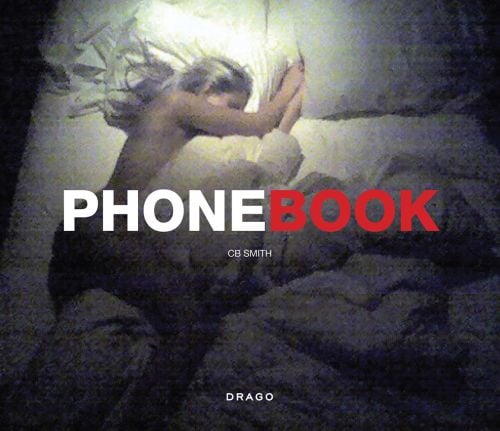 Grainy aerial shot of white naked female sleeping on bed with legs wrapped around duvet, PHONEBOOK in white and red font to centre.