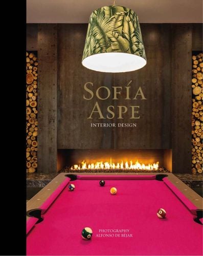 Pink felt pool table with lit fireplace in background, on cover of 'Sofia Aspe, Interior Design', by Ediciones El Viso.