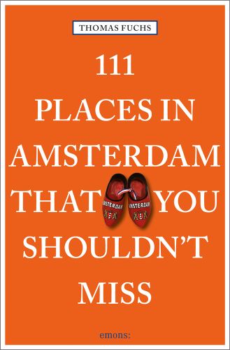 Pair of red clogs near centre of orange cover of '111 Places in Amsterdam That You Shouldn't Miss', by Emons Verlag.