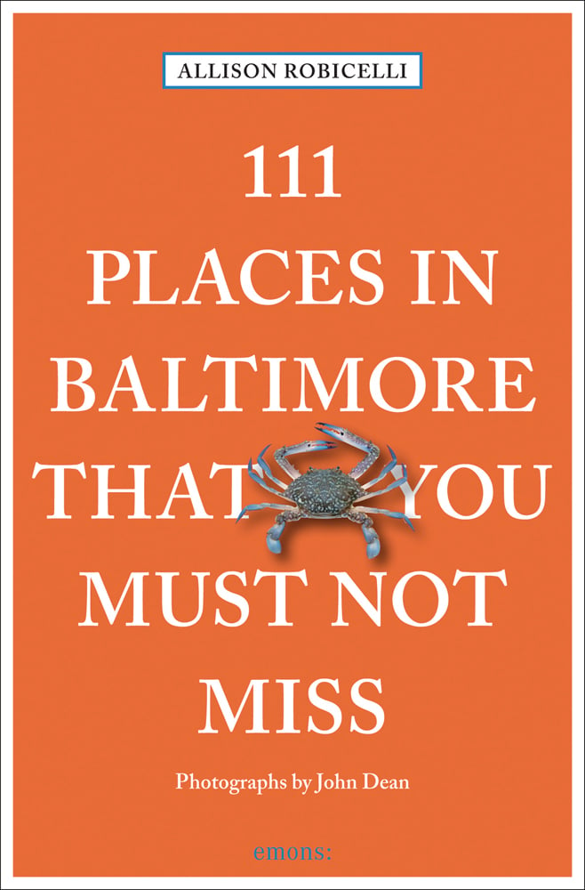 Maryland crab near centre of orange cover of '111 Places in Baltimore That You Must Not Miss', by Emons Verlag.