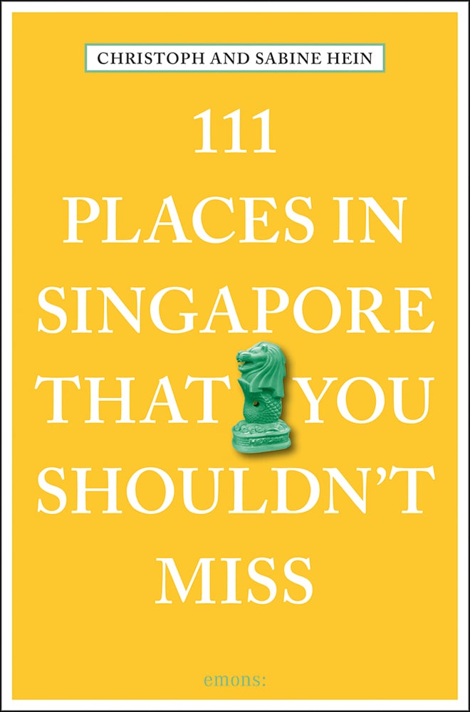 Green Merlion mascot near centre of yellow-orange cover of '111 Places in Singapore That You Shouldn't Miss', by Emons Verlag.