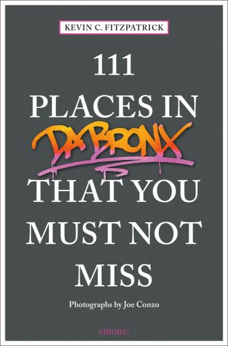 Orange and pink graffiti, near centre of dark grey cover of '111 Places in the Bronx That You Must Not Miss', by Emons Verlag.