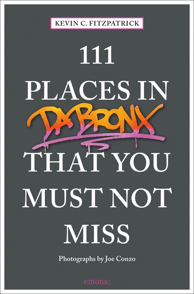 Orange and pink graffiti, near centre of dark grey cover of '111 Places in the Bronx That You Must Not Miss', by Emons Verlag.