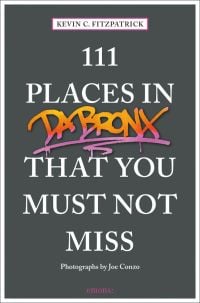 Orange and pink graffiti, near center of dark grey cover of '111 Places in the Bronx That You Must Not Miss', by Emons Verlag.