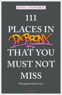 Orange and pink graffiti, near center of dark grey cover of '111 Places in the Bronx That You Must Not Miss', by Emons Verlag.