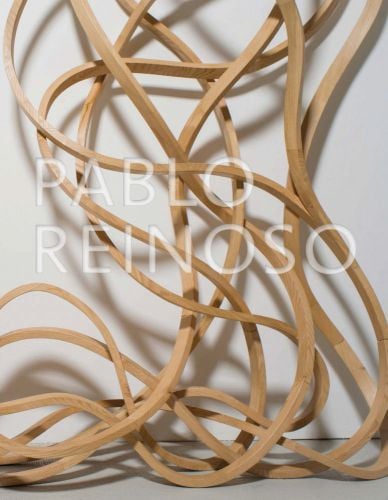 Curly mass of beige rubber bands, white cover, PABLO REINOSO in transparent white embossed font to centre.