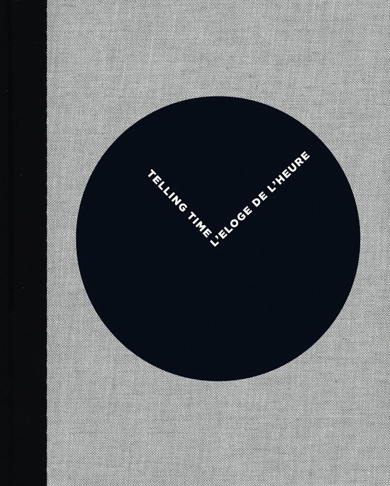 Grey book cover of L'Eloge de l'Heure | Telling Time, featuring a black circle with white font in shape of clock hands. Published by 5 Continents Editions.