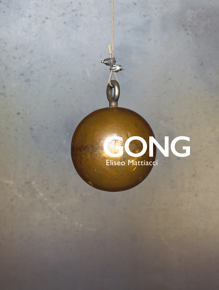 Gold sphere hanging from thin rope, on pale blue flecked cover of 'GONG, Eliseo Mattiacci', by Forma Edizioni.