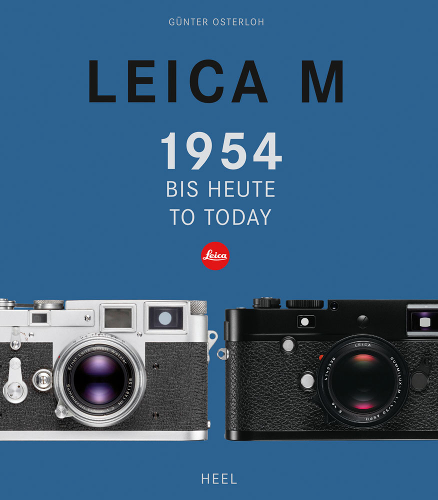 2 Leica M slr cameras, on blue cover, LEICA M 1954 TO TODAY in black and grey font above