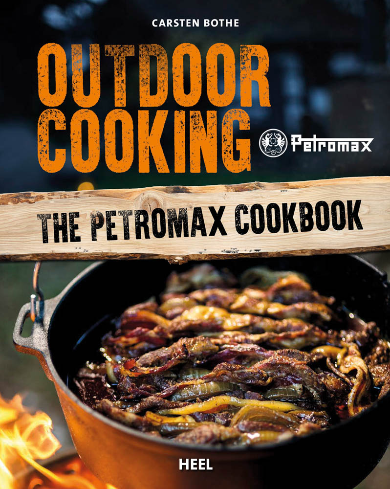 Iron pan of food cooking over fire, OUTDOOR COOKING in orange font above, The Petromax Cookbook in black on wood