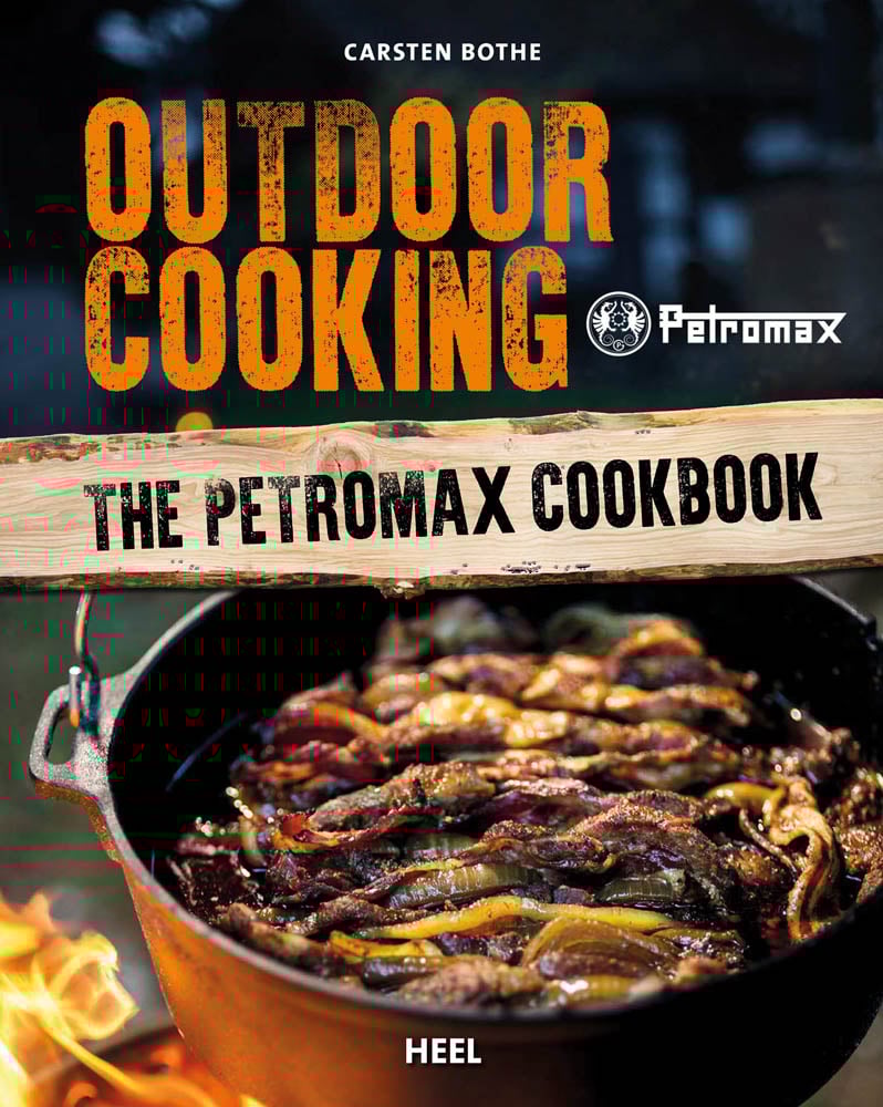 Iron pot of food cooking over fire, on cover of 'Outdoor Cooking, The Petromax Cookbook', by HEEL.