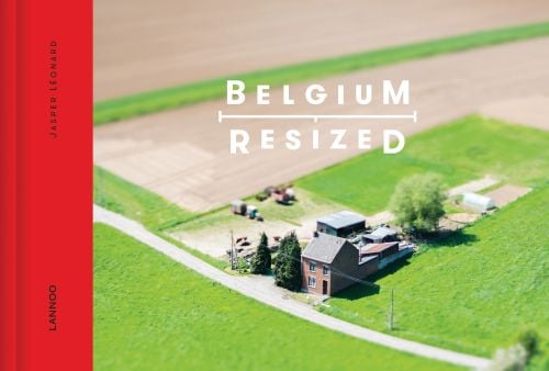 Aerial shot of detached farmhouse surrounded by fields, on cover of 'Belgium Resized', by Lannoo Publishers.