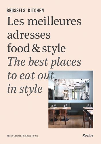 Interior of restaurant with table and glasses, on cover of 'Brussels' Kitchen, The Best Places to Eat Out in Style', by Lannoo Publishers.