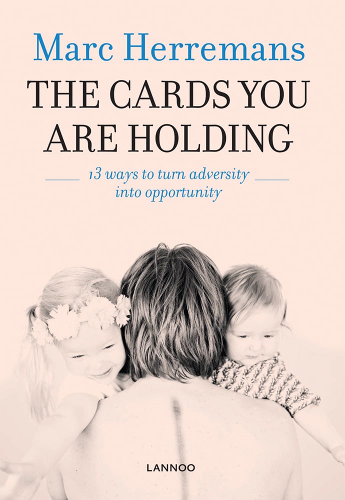 Person facing away, holding two young children over her shoulders, on cover of 'The Cards you are Holding, 13 ways to turn adversity into opportunity', by Lannoo Publishers.