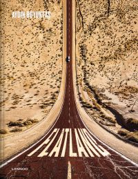 Aerial view of car on road driving through desert, on cover of 'Flatland', by Lannoo Publishers.